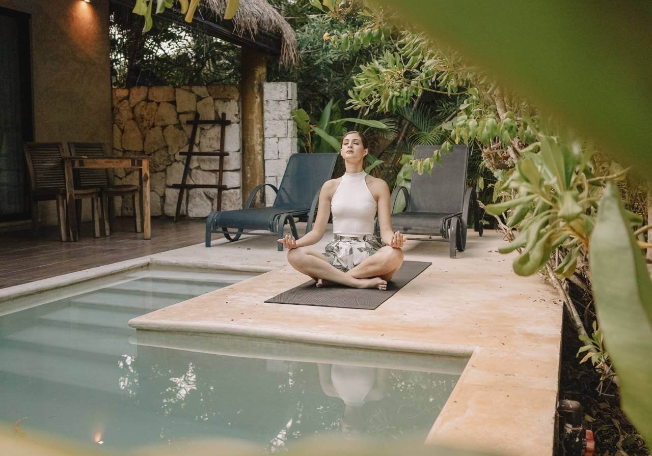 mujer hacuendo yoga en hotel